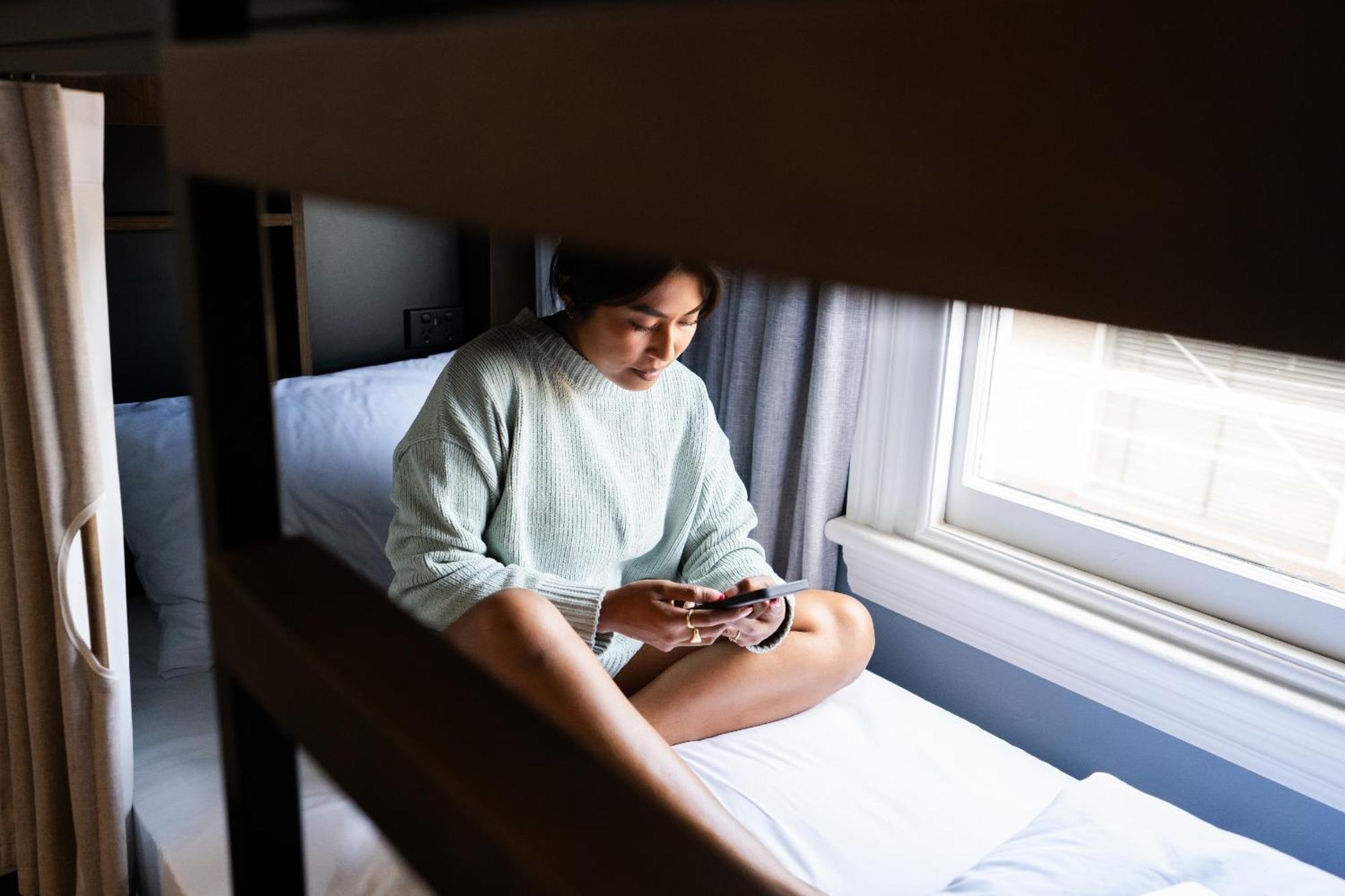 Haka House Крайстчёрч Номер фото A woman sitting on a bunk bed
