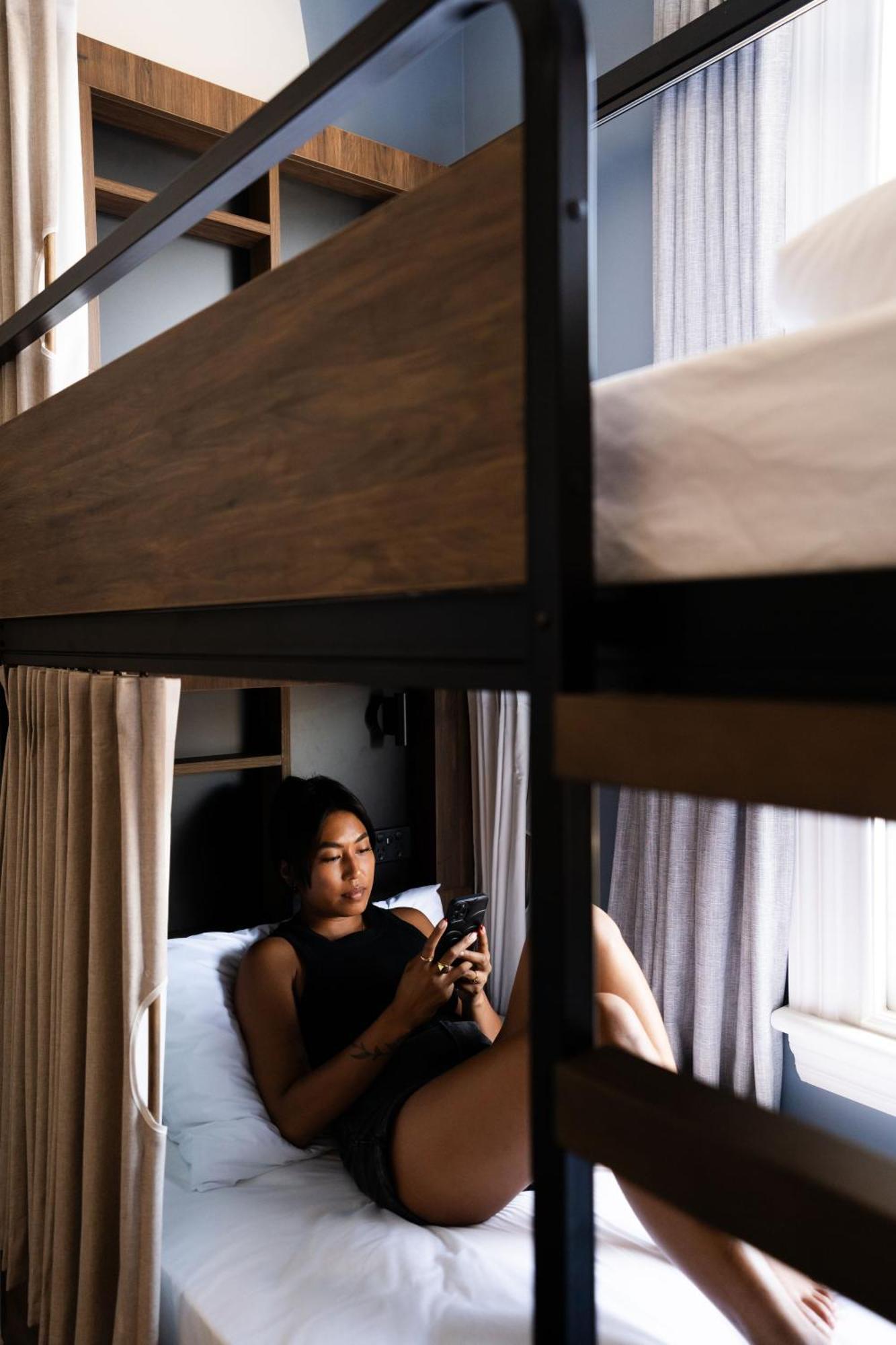 Haka House Крайстчёрч Экстерьер фото A woman using a mobile phone in a hostel